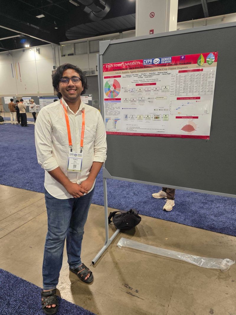 A student in a white shirt and CVPR lanyard standing beside a research poster in a convention-center poster hall.